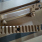 Beige metal tactical m16 carry handle and rail and clip on a cardboard background