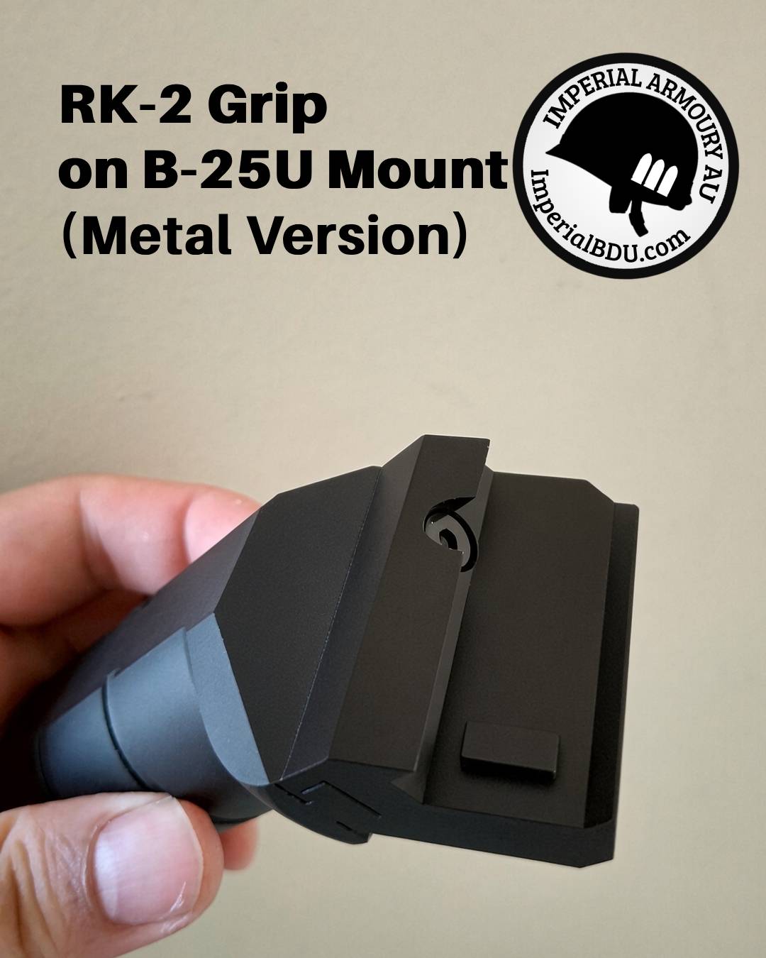 A hand holding a black metal RK-2 grip attachment for a B-25U mount, shown against a plain beige background with product text and an Imperial Armoury logo.